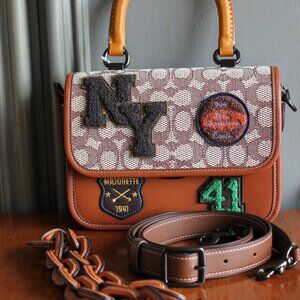 NWT Rogue Top Handle in Signature Textile Jacuard with Varsity Patches.